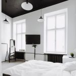 просторная спальня с темной мебелью и белыми стенами