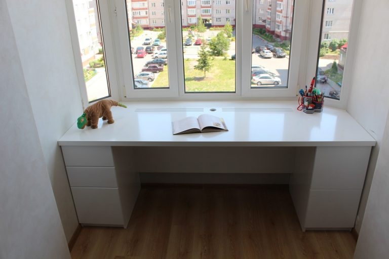 Письменный стол у окна со шкафами