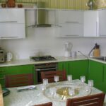 зеленая кухня с деревянными стульями