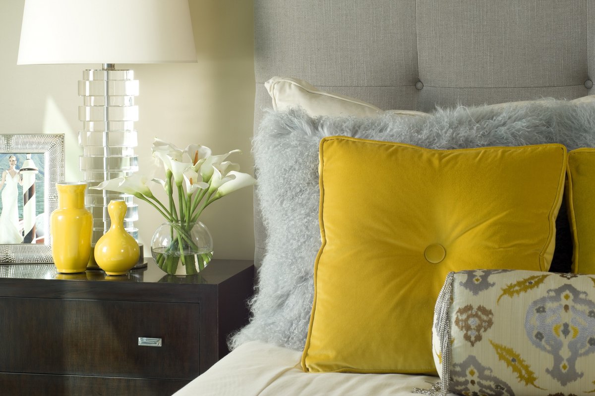 Подушки к желтому дивану в интерьере гостиной.